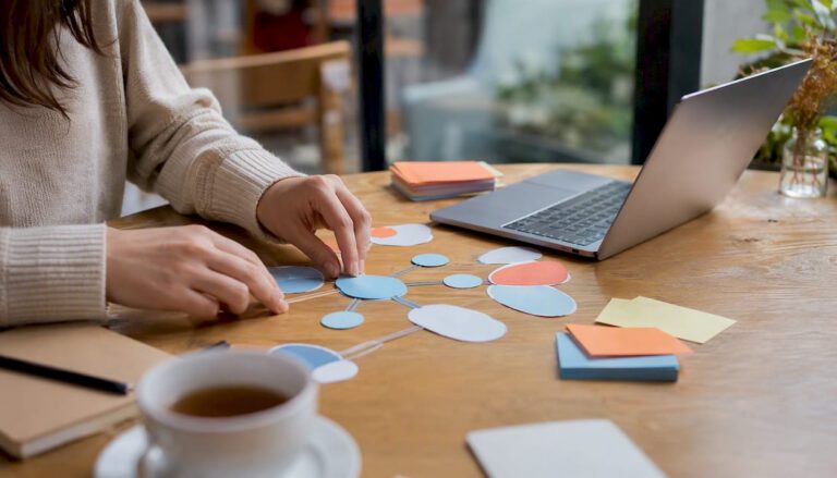Hands arranging keyword cloud printouts on desk